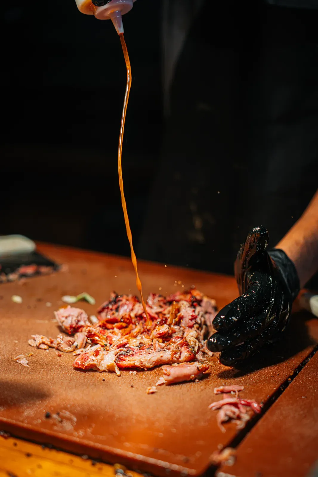 Barbecue sauce poured over freshly chopped smoked meat
